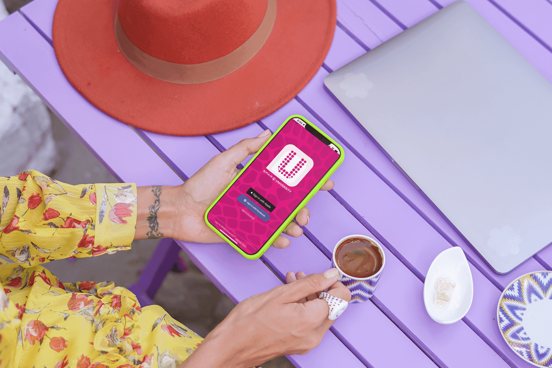 Een student gebruikt de spar university app op haar telefoon aan een picknicktafel